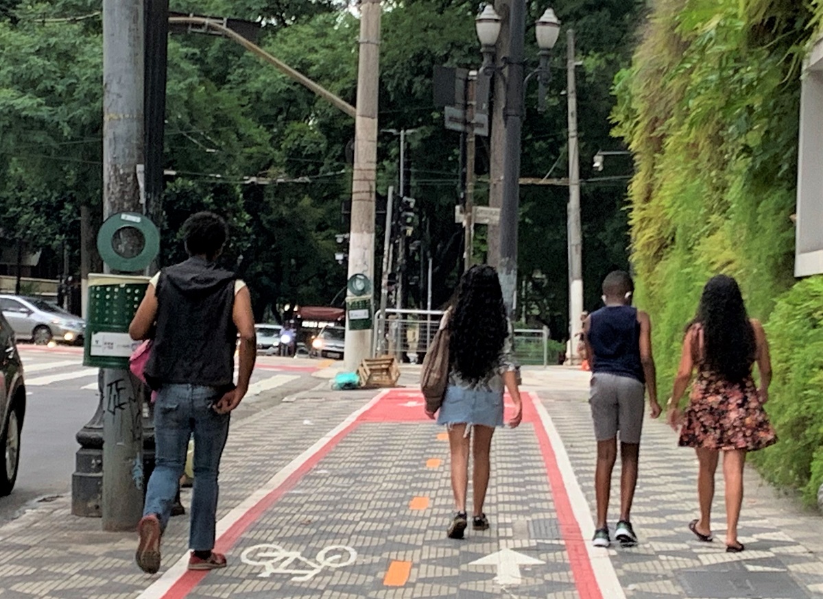 Pedestres andam sobre faixa destinada a ciclistas em uma calçada no centro de São Paulo