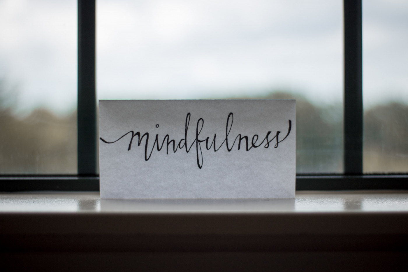 Casa com u cartão com a palacra mindfulness escrito a mão perto da janela