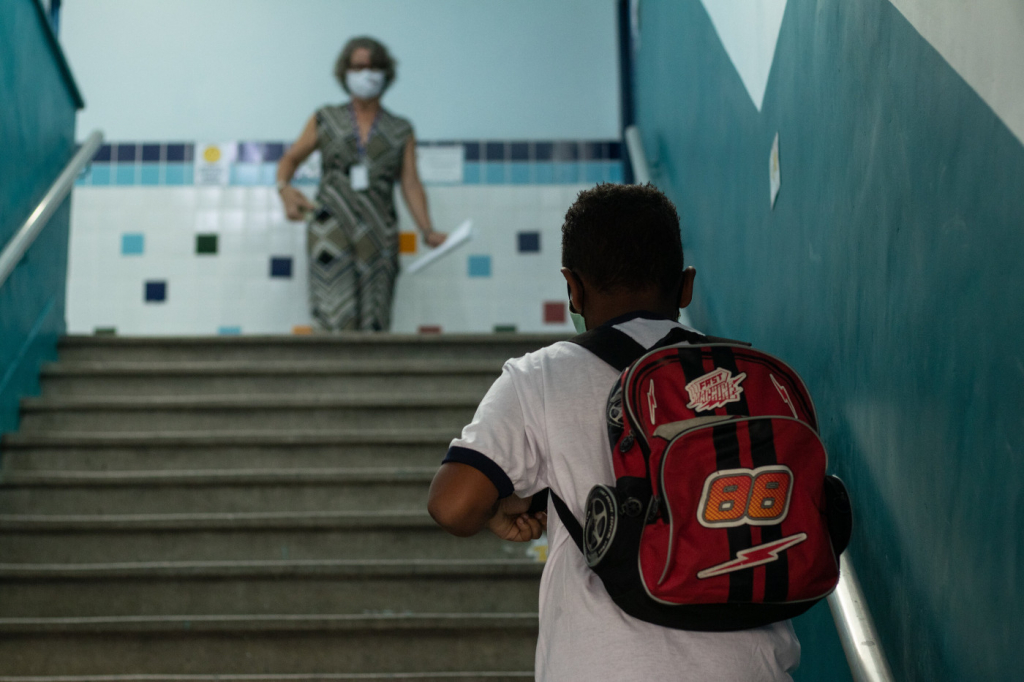 Profissional da educação aguarda chegada de aluno para volta às aulas presenciais