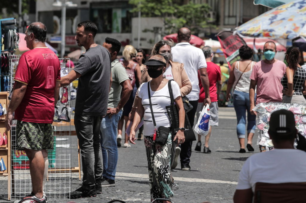 Pessoas caminham no centro do Rio de Janeiro utilizando máscaras de proteção contra a Covid-19