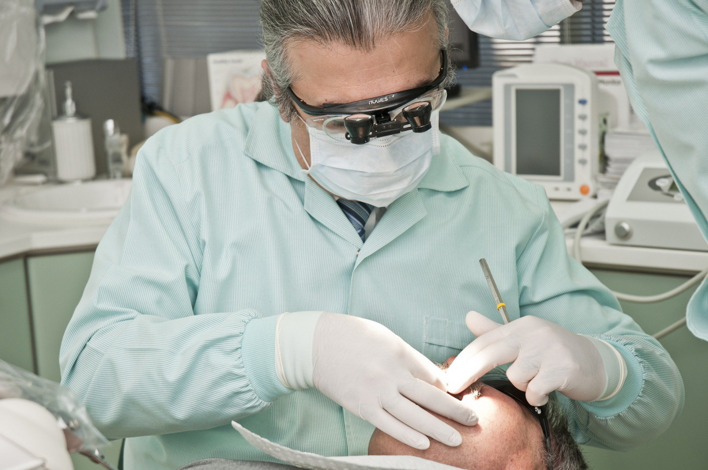 Dentista avalia saúde bucal de paciente dentro de um consultório