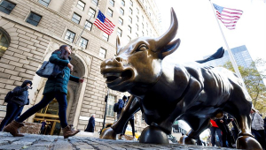 Pessoas caminham perto da estátua do touro de Wall Street, em Nova York, Estados Unidos