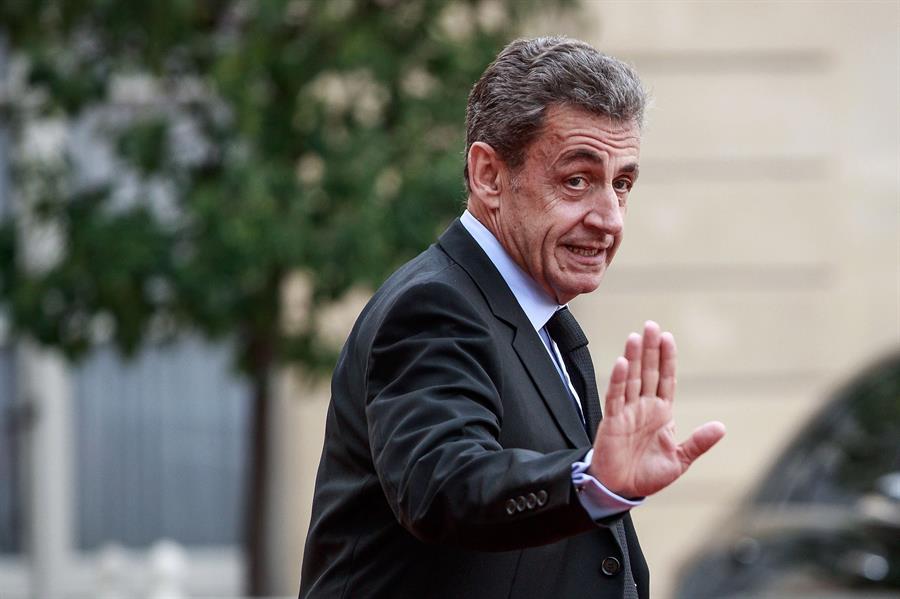 O ex-presidente da França, Nicolas Sarkozy, acena para os fotógrafos