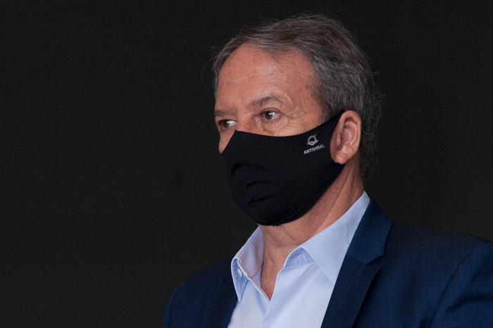 Em um fundo preto, o secretário de Saúde de São Paulo, Edson Aparecido de máscara