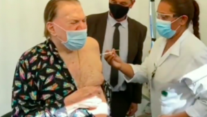 Silvio Santos de pijamas recebendo a segunda dose da vacina contra Covid-19