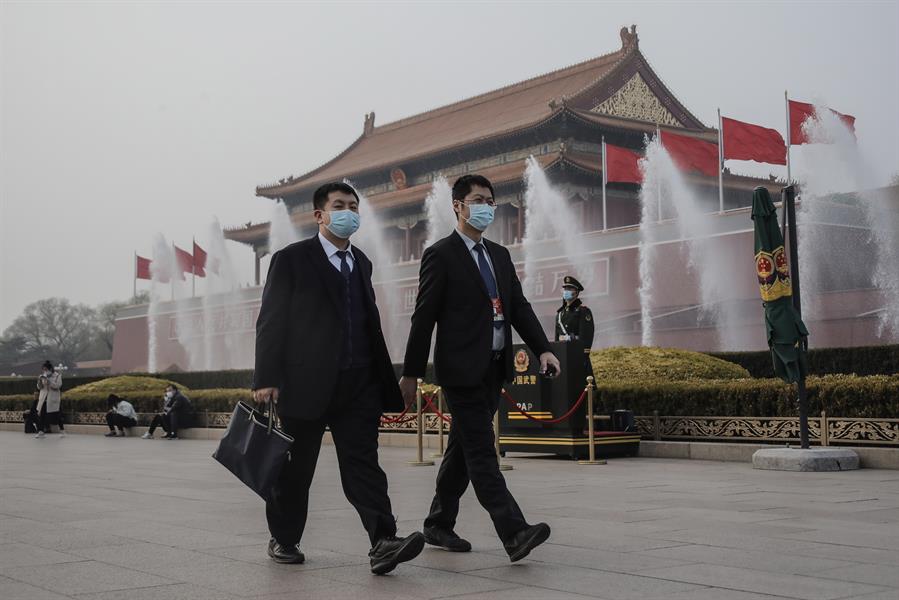 Cidadãos da China caminham com máscaras de proteção contra a Covid-19