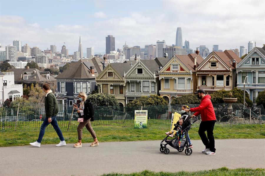 Família usando máscara de proteção caminha em frente às Painted Ladies em San Francisco, Estados Unidos