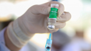 Enfermeira colocando dose da vacina da AstraZeneca/Oxford na seringa