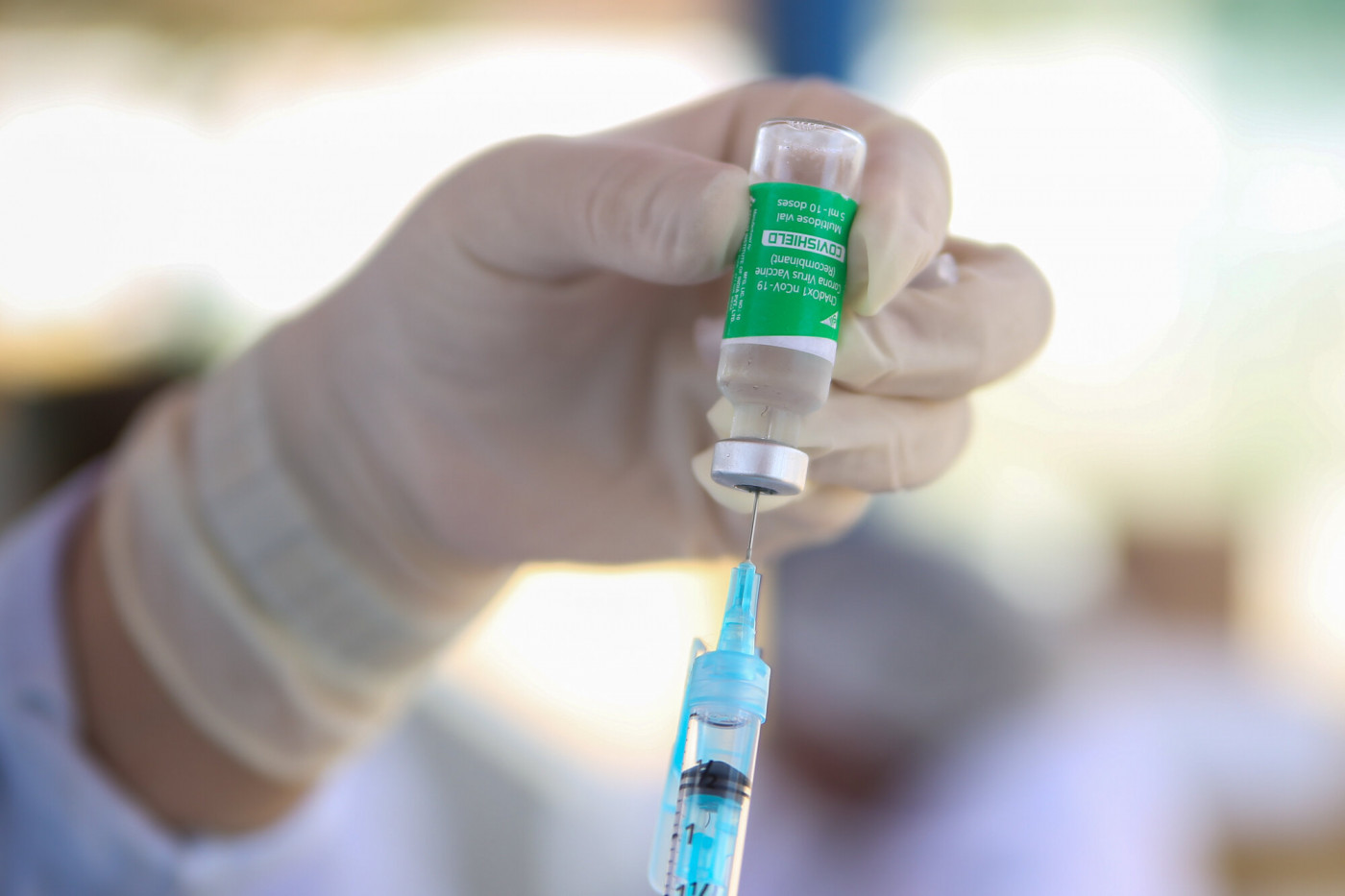 Enfermeira colocando dose da vacina da AstraZeneca/Oxford na seringa