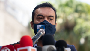 Cláudio Castro, governador do Rio, dá entrevista coletiva usando uma máscara escura