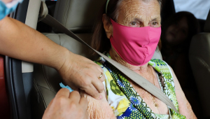 Dentro do carro, no banco do passageiro, idosa é vacinada em Foz do Iguaçu