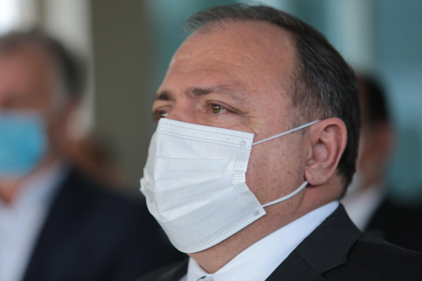 O ministro da Saúde, Eduardo Pazuello, parado de lado, usando máscara