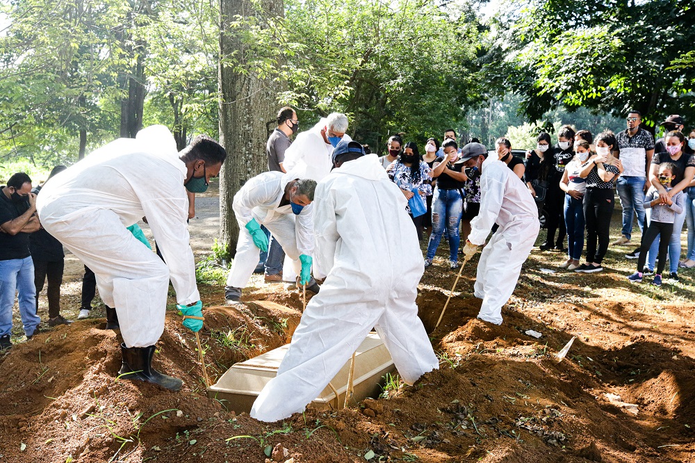 Vestidos com roupas de proteção, coveiros enterram vítima da Covid-19 na Vila Formosa