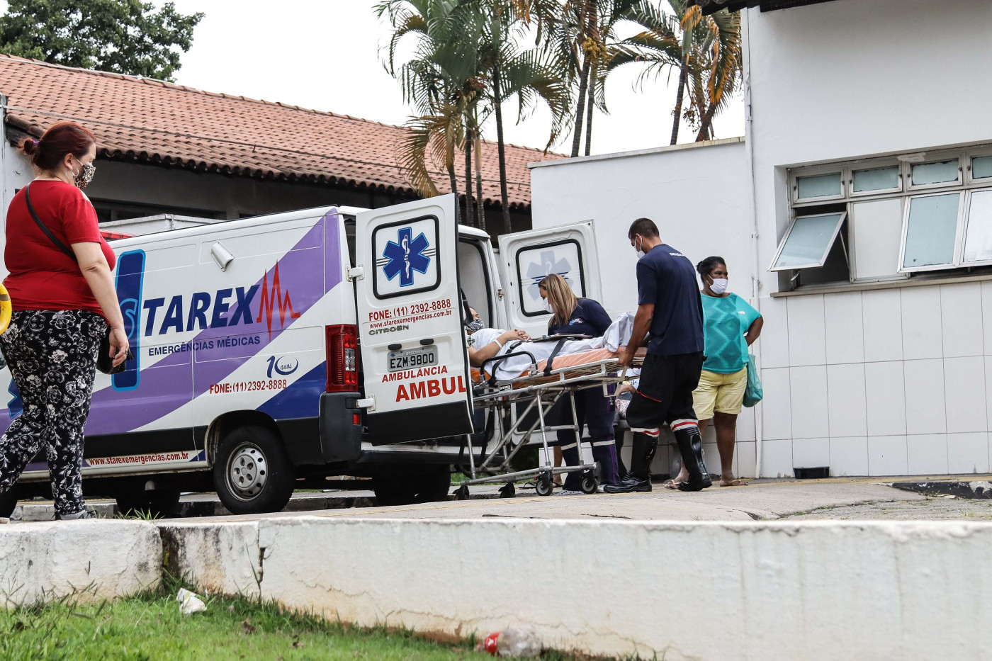Três pessoas retiram maca de uma ambulância em frente ao hospital municipal Vereador Jose Storopolli, no bairro do Parque Novo Mundo, Zona Norte de São Paulo