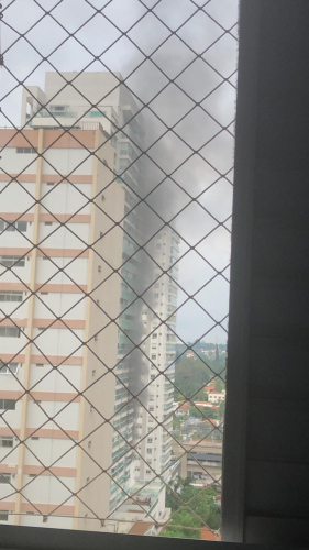 Vista de um prédio com fumaça pela varanda de outro apartamento