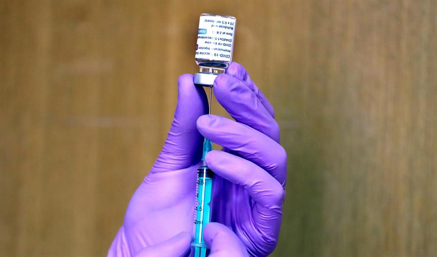Profissional da saúde coloca vacina contra Covid-19 em seringa