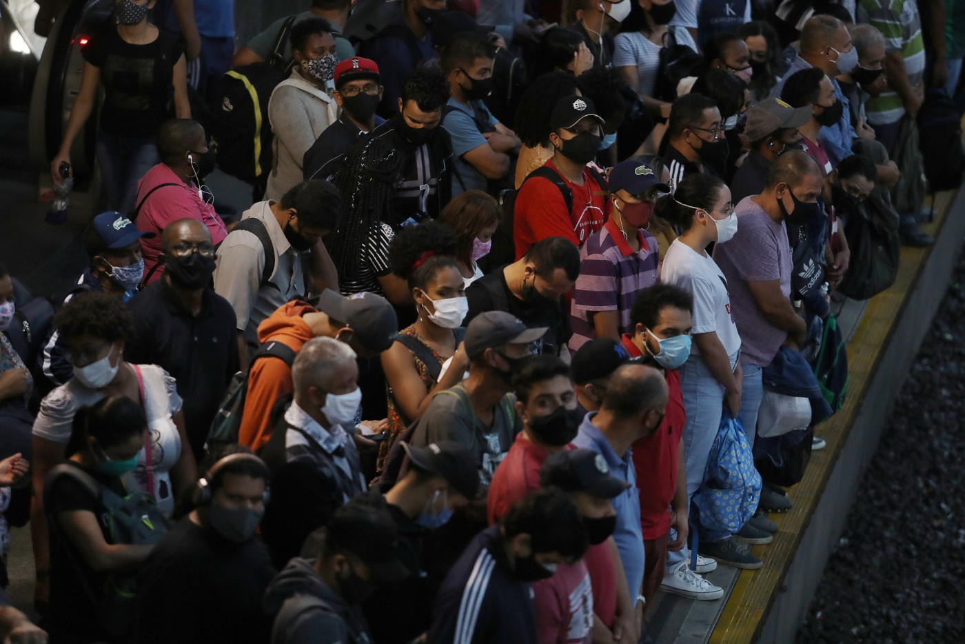 Multidão se aglomerando em plataforma de trem