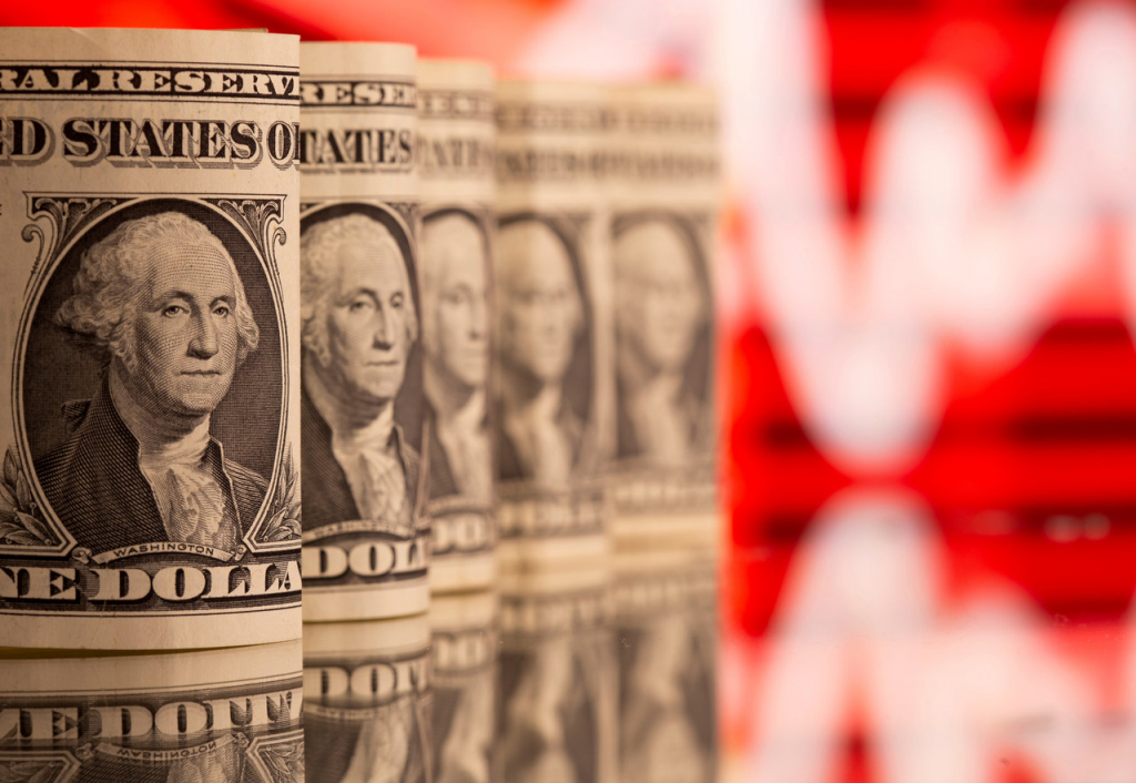 Cédulas de dólar enroladas em frente um fundo vermelho