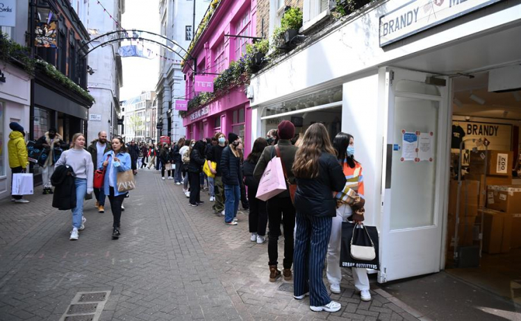 Pessoas fazem fila do lado de fora de lojas em Londres, que reabriram nesta segunda-feira, 12