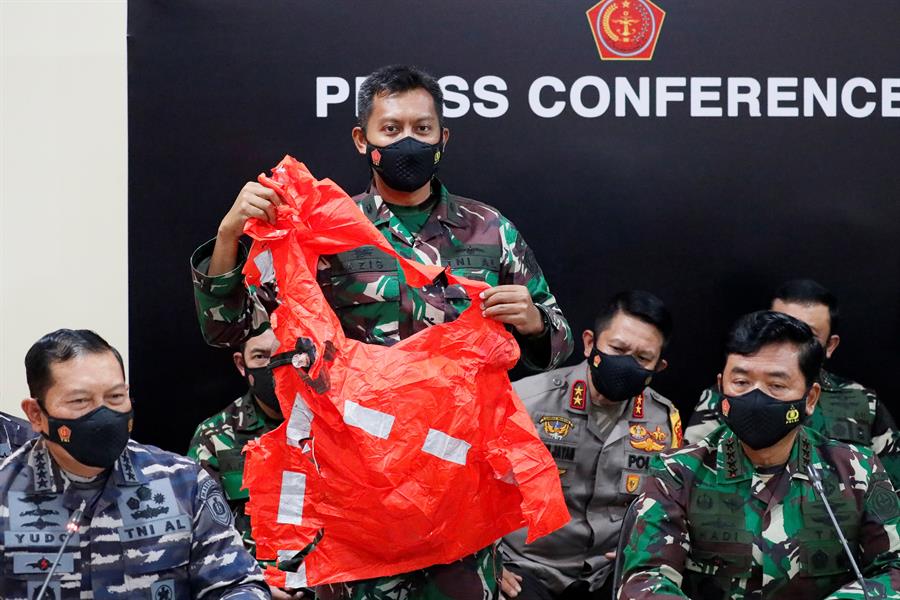 Oficias da Marinha da Indonésia seguram um colete salva-vidas