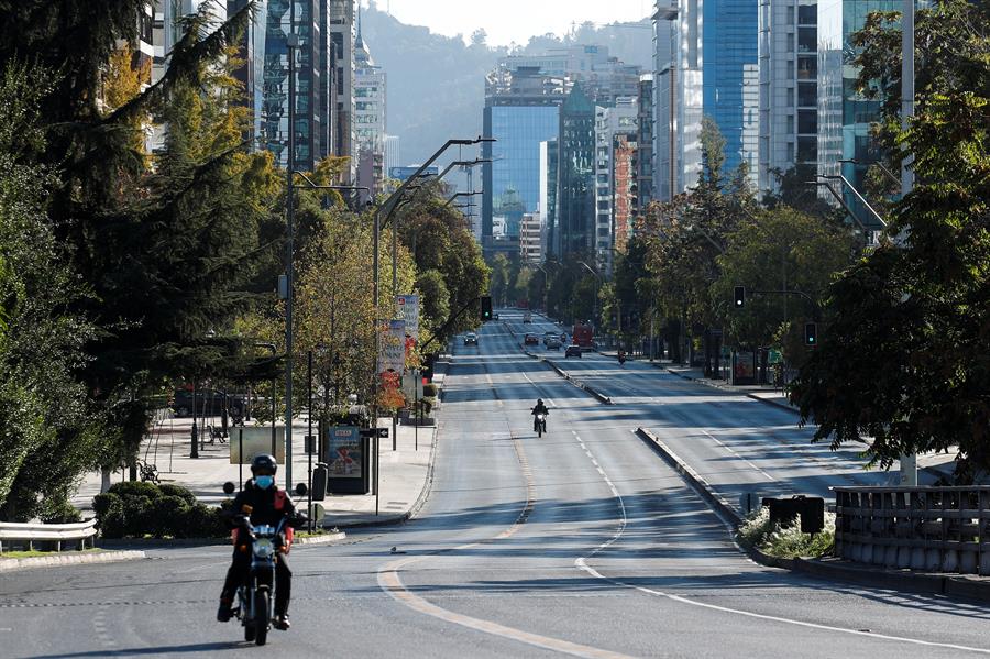 Motorista circula por uma avenida quase vazia em Santiago do Chile