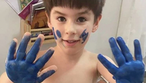 Criança com mão pintada de azul
