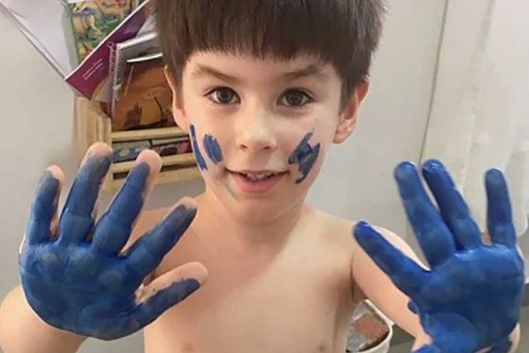 Criança com mão pintada de azul