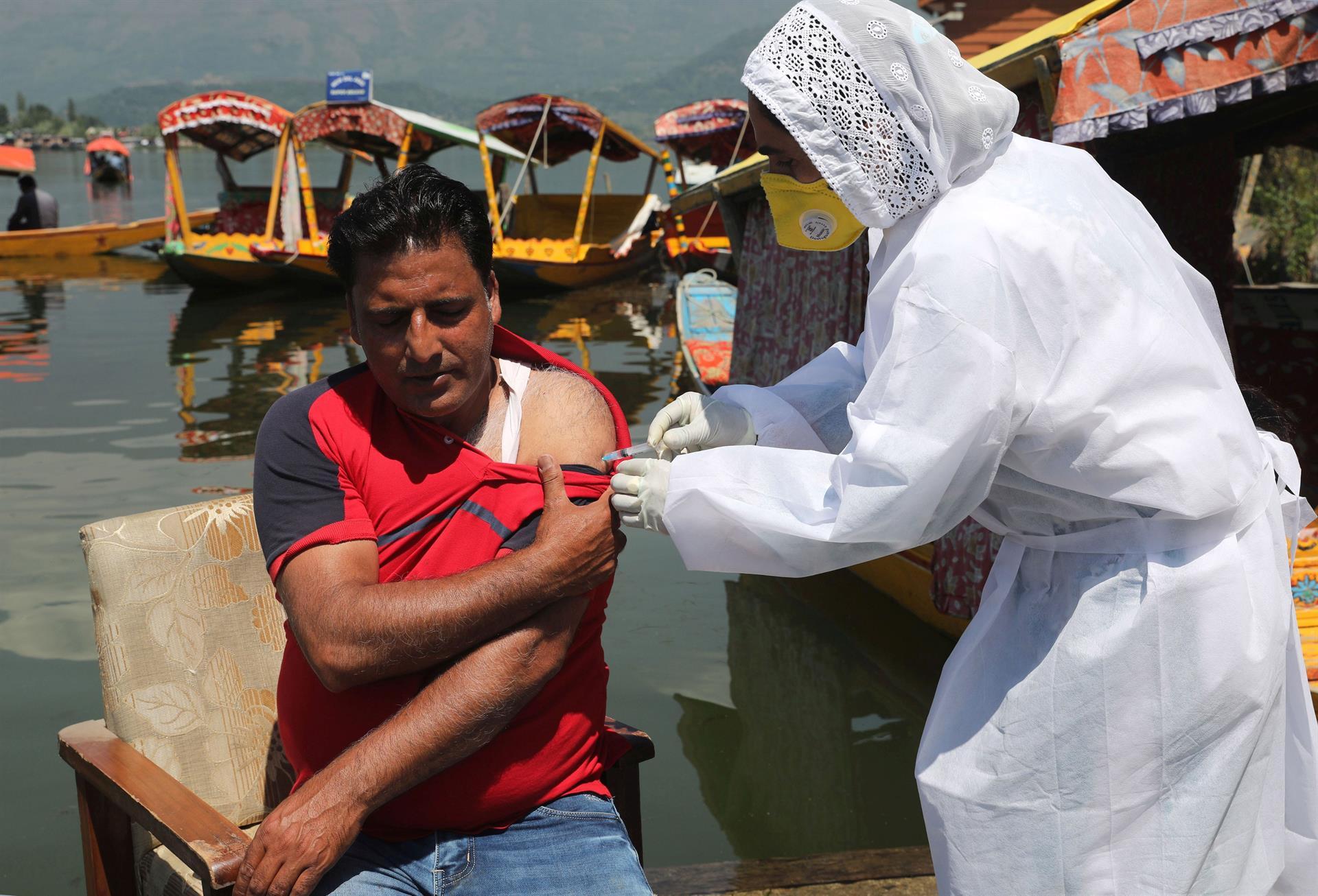 Homem da Caxemira indiana recebe uma injeção de vacina contra Covid-19 durante uma campanha de vacinação nas margens do Lago Dal em Srinagar