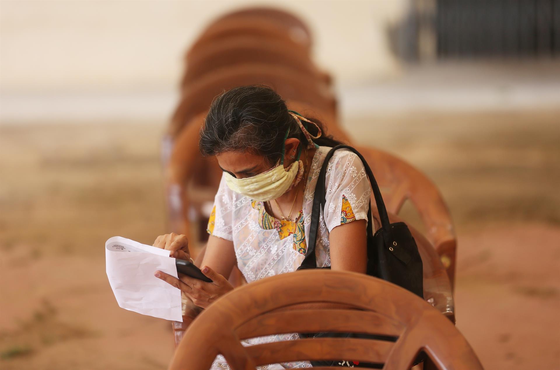 Mulher preenche formulário antes de receber a vacina contra a Covid-19 durante campanha em Bangalore, Índia
