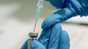 Profissional da saúde coloca vacina contra Covid-19 em seringa para aplicação