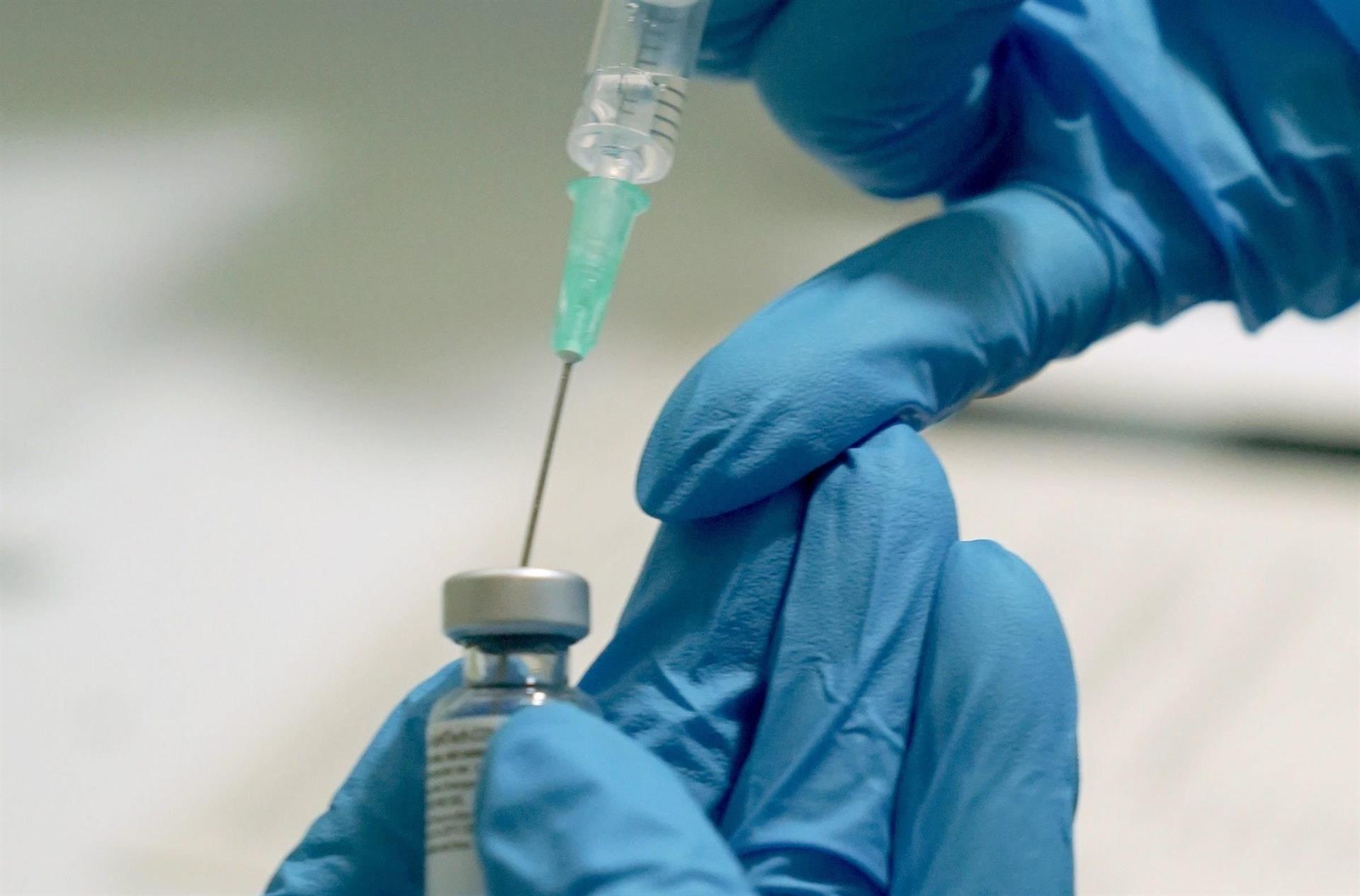 Profissional da saúde coloca vacina contra Covid-19 em seringa para aplicação