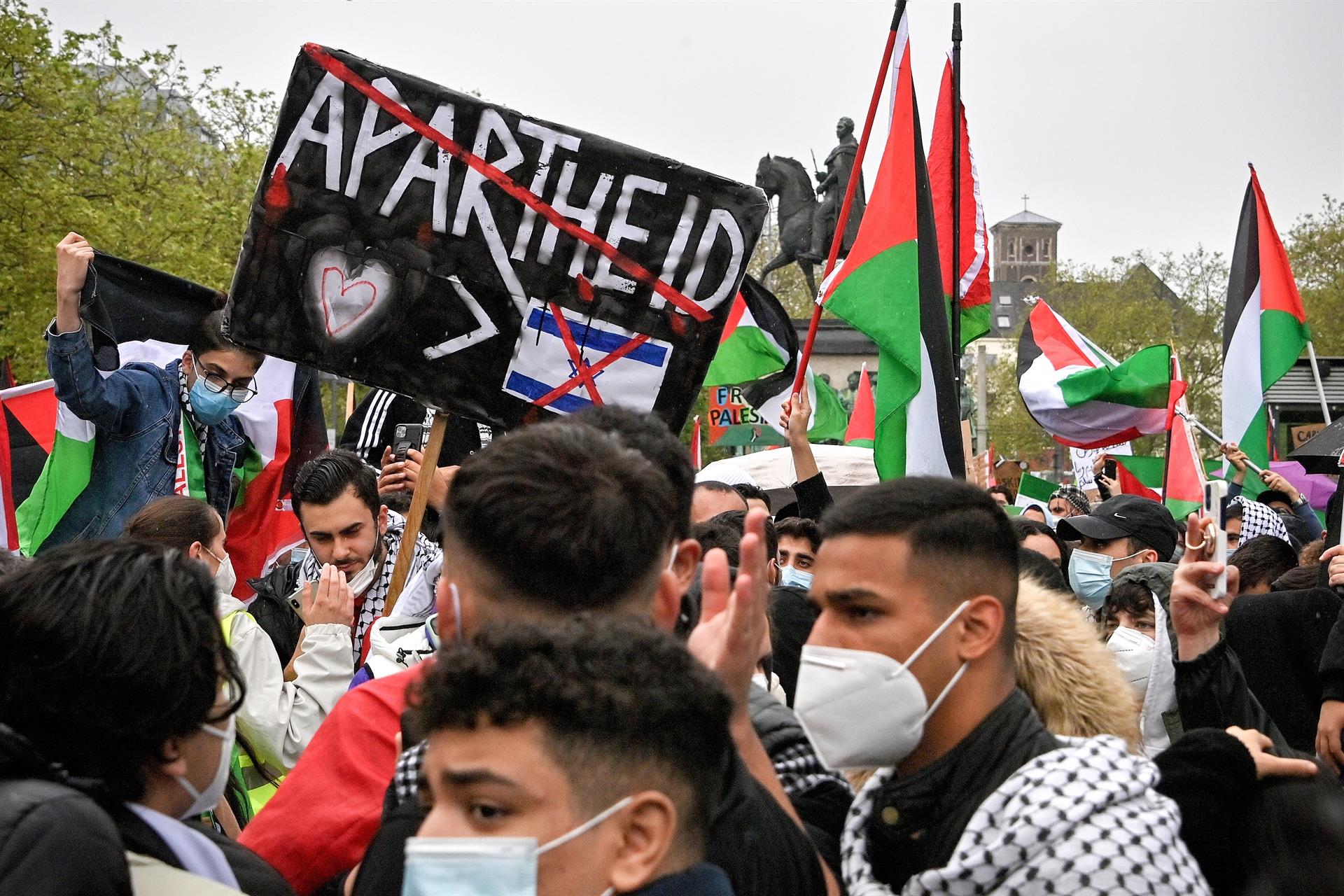 Em Colônia, na Alemanha, manifestantes seguram cartaz que insinua que Israel mantém a Palestina em um regime de apartheid