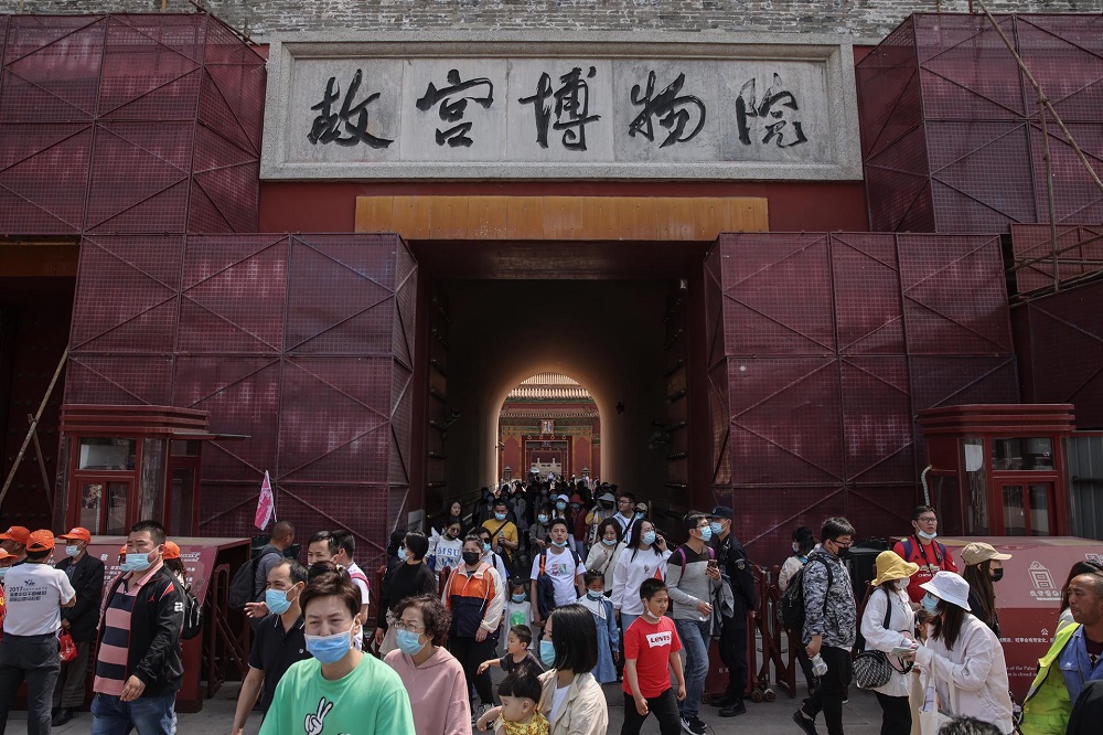 Turistas caminham fora da Cidade Proibida em Pequim
