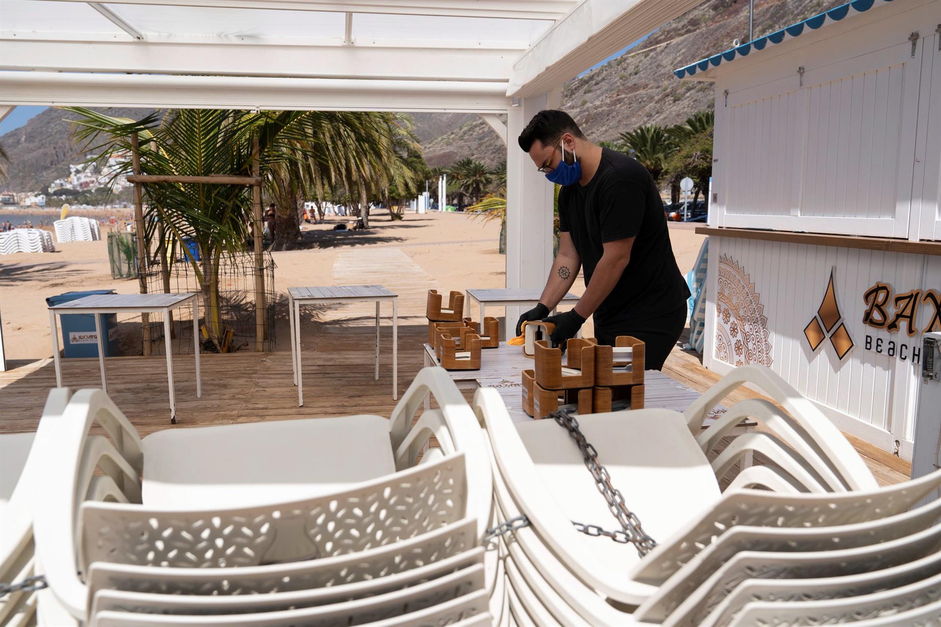 Funcionário arruma cadeiras de praia nas Ilhas Baleares, Espanha