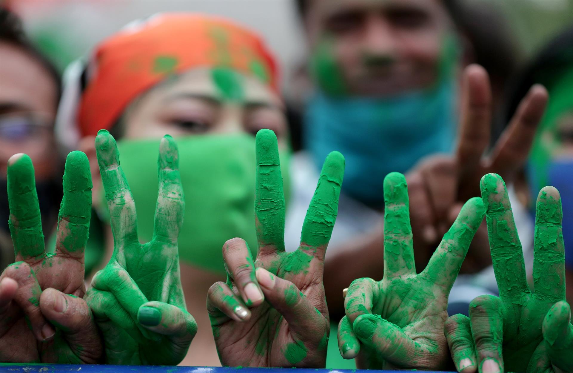 Apoiadores do partido Trinamool Congress (TMC) mostram um sinal de vitória ao celebrar depois de ganhar a maioria absoluta nas eleições para a Assembleia de Bengala Ocidental em Calcutá, Índia