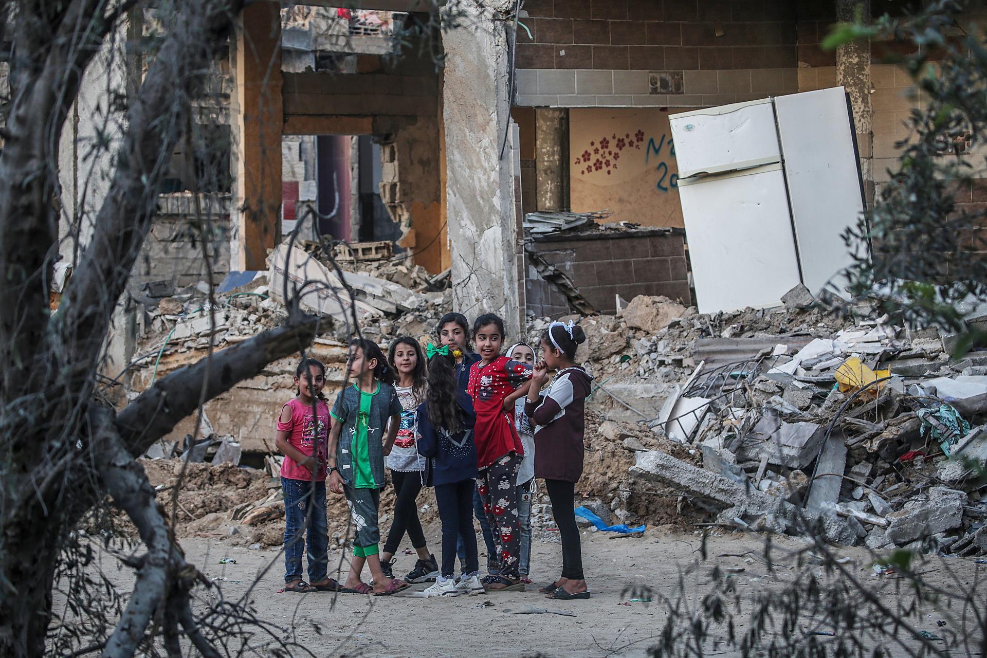 Meninas palestinas brincam entre os escombros das casas de suas famílias destruídas na cidade de Beit Hanoun, norte da Faixa de Gaza