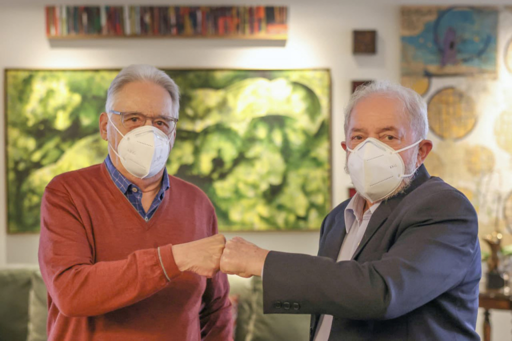 Imagem dos ex-presidentes FHC e Lula de máscara e de cumprimentando com um toque de mão