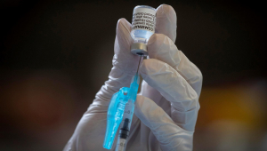 Profissional da saúde retira dose da vacina contra Covid-19 de ampola com uma seringa