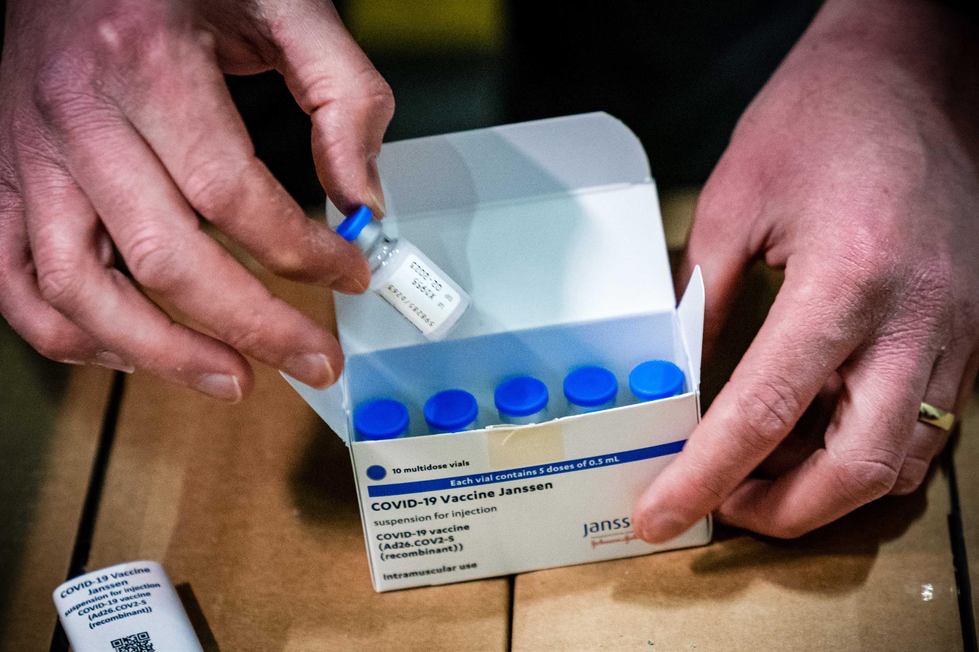 Pessoa abre caixas com doses da vacina da Janssen contra a Covid-19