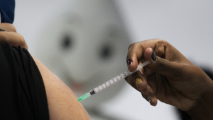 Braço de uma mulhe recebendo a dose de uma vacina contra a Covid-19