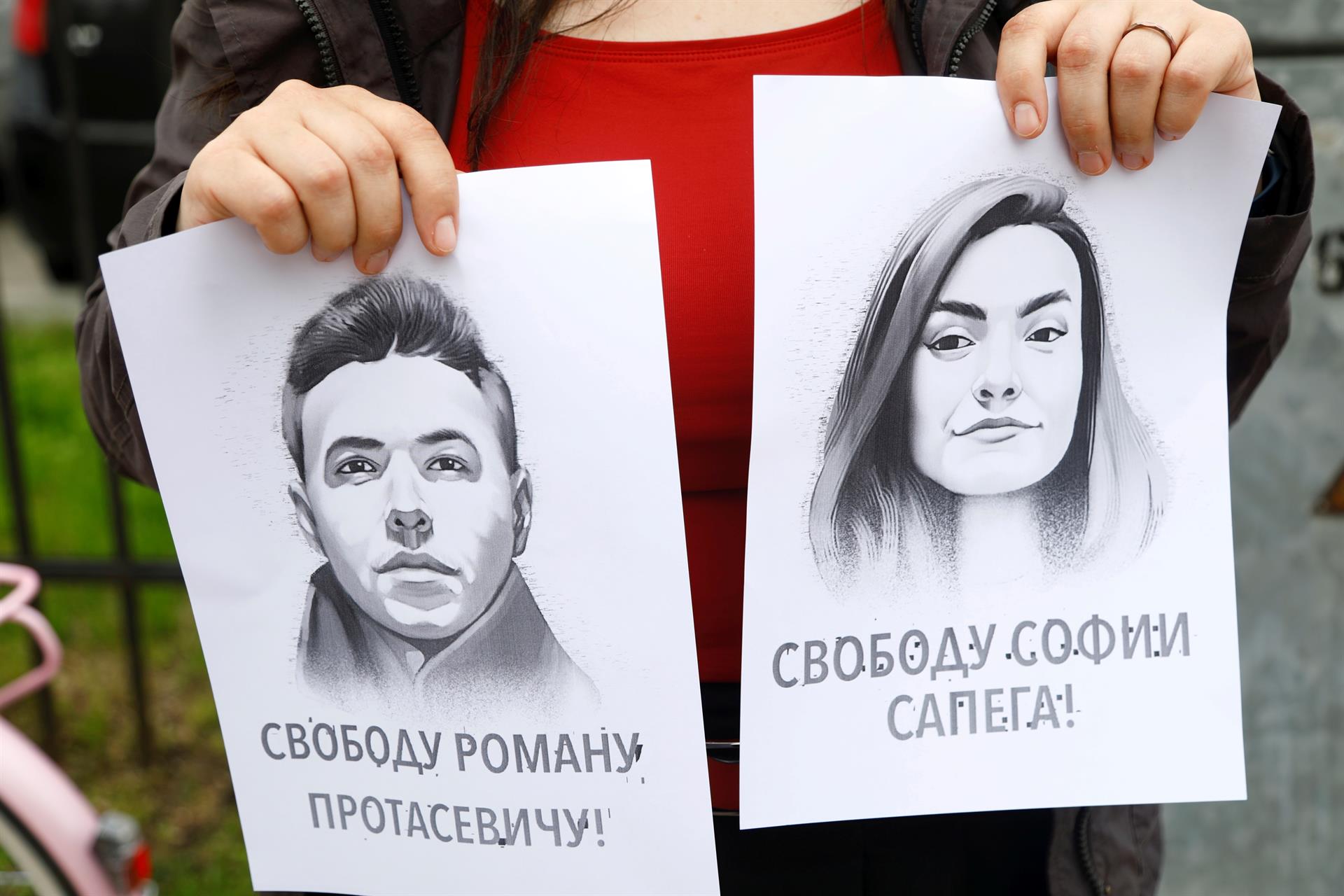 Uma mulher segura um retrato do jornalista da oposição Roman Protasevich e sua namorada Sofia Sapega durante um protesto de solidariedade a Roman Protasevic na embaixada da Bielo-Rússia em Riga, Letônia
