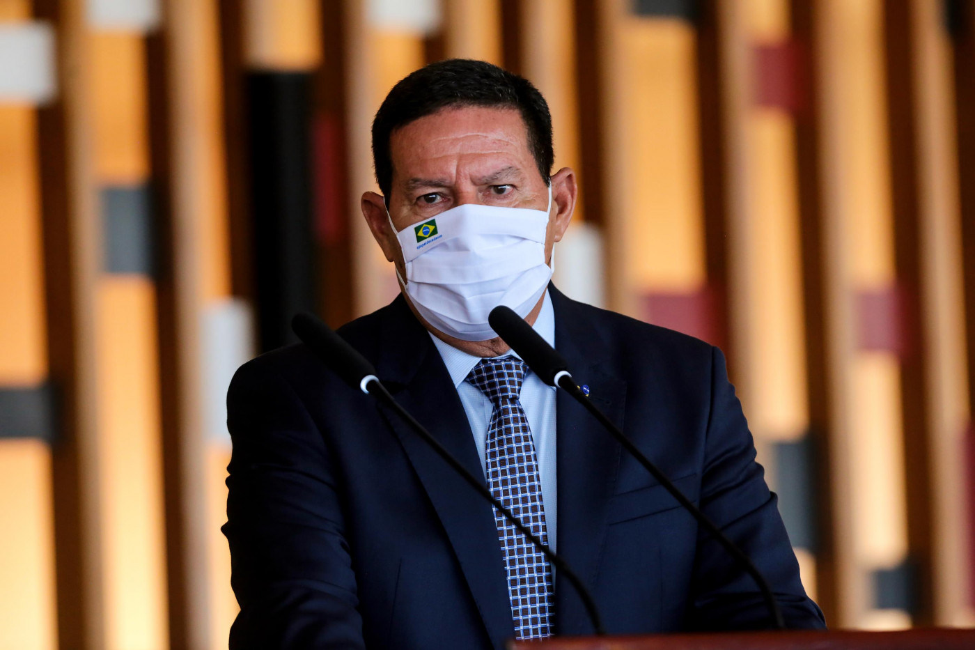 Hamilton Mourão, vice-presidente da República, usa máscara de proteção branca e terno preto durante coletiva do Conselho da Amazônia