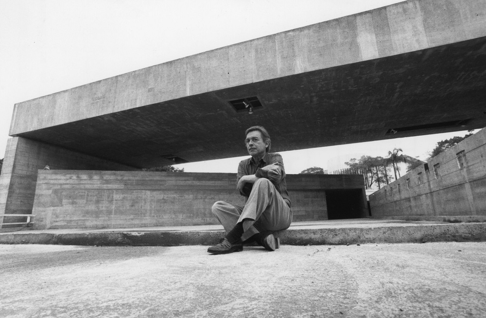 O arquiteto Paulo Mendes da Rocha sentado em frente ao MuBE, sua obra mais icônica