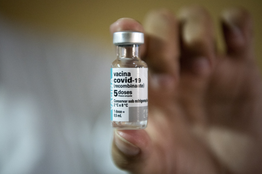 Profissional da saúde mostra frasco da vacina de Oxford