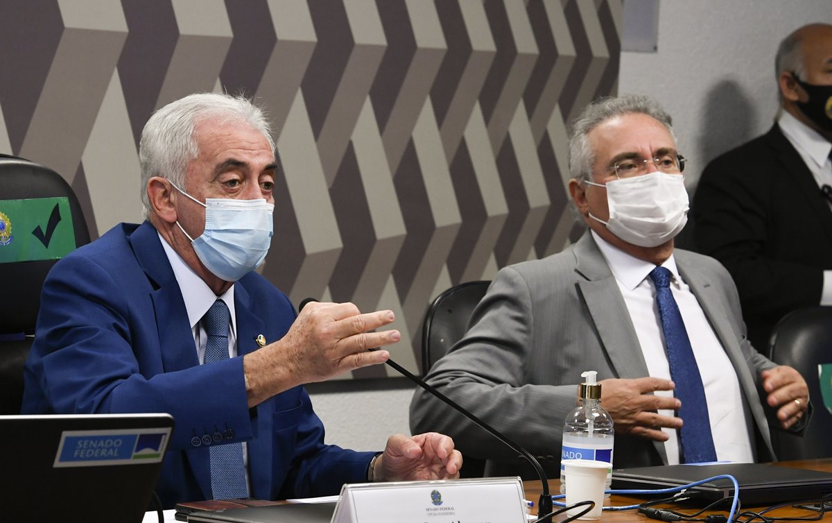 Dois senadores de máscara na mesa da presidência da CPI