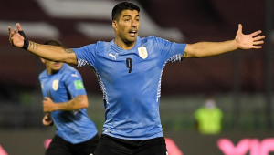 Com camisa azul clara e calção preto, Luis Suárez abre os braços durante jogo do Uruguai