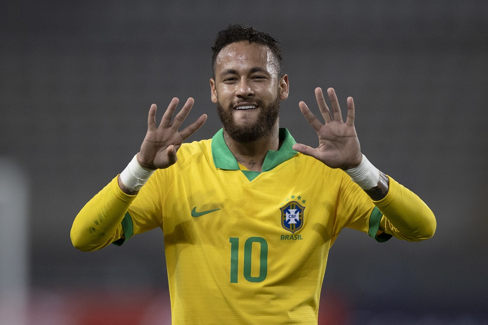 Vestindo a camisa amarelinha da seleção, Neymar faz o número nove com as duas mãos