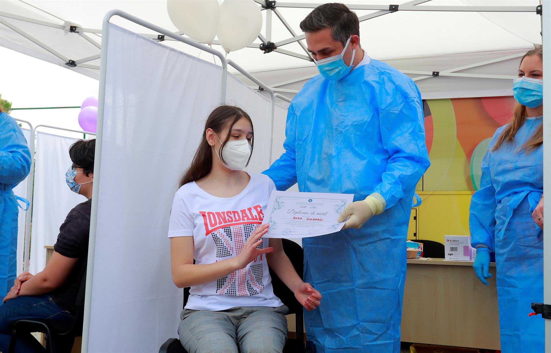Menina recebe certificado de vacinação contra a Covid-19 em posto na Romênia