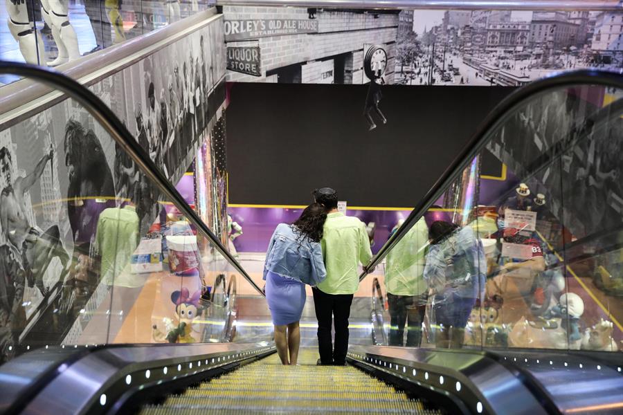 Pessoas em escada rolante de shopping