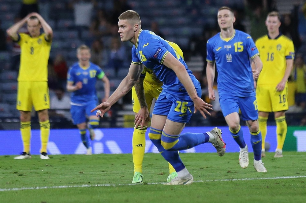 O jogador ucraniano Dovbyk sai em disparada, com o corpo um tanto curvado, após marcar o gol da classificação de sua seleção